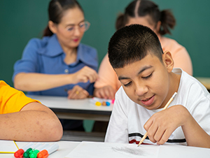 Allied health assistant helps child on the autism spectrum at school