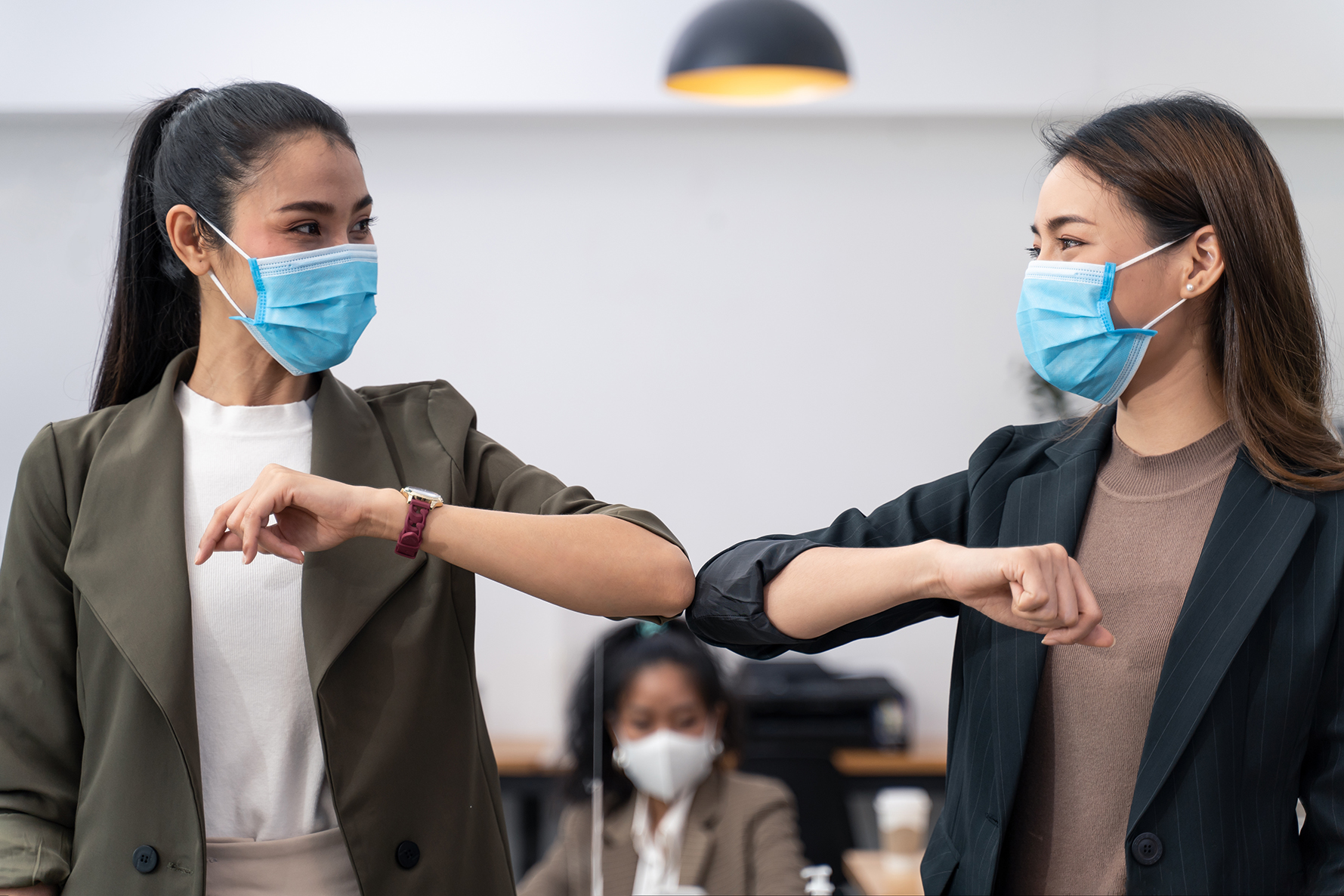 Allied health assistants bump elbows and wear masks during coronavirus restrictions