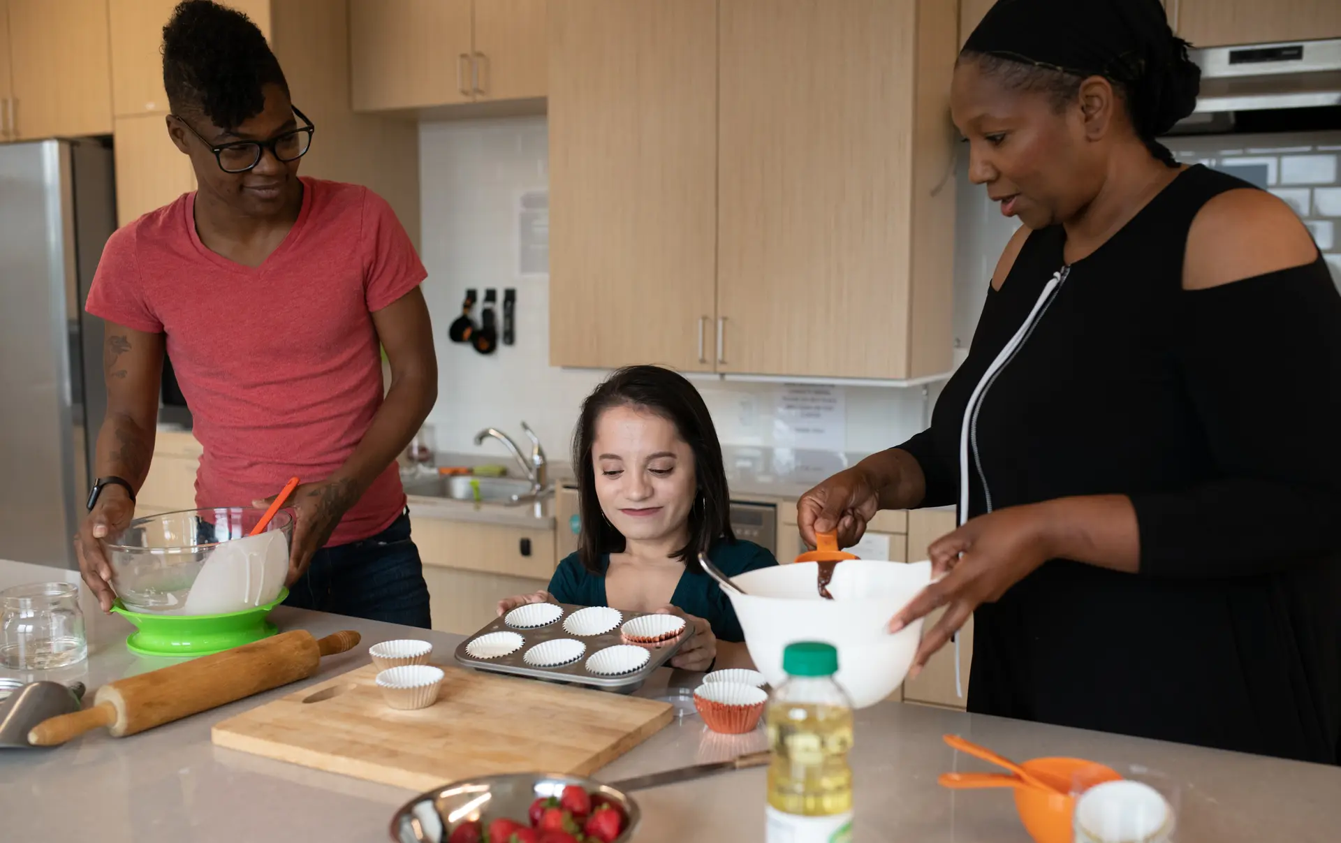 Three disabled people baking together in an accessible kitchen